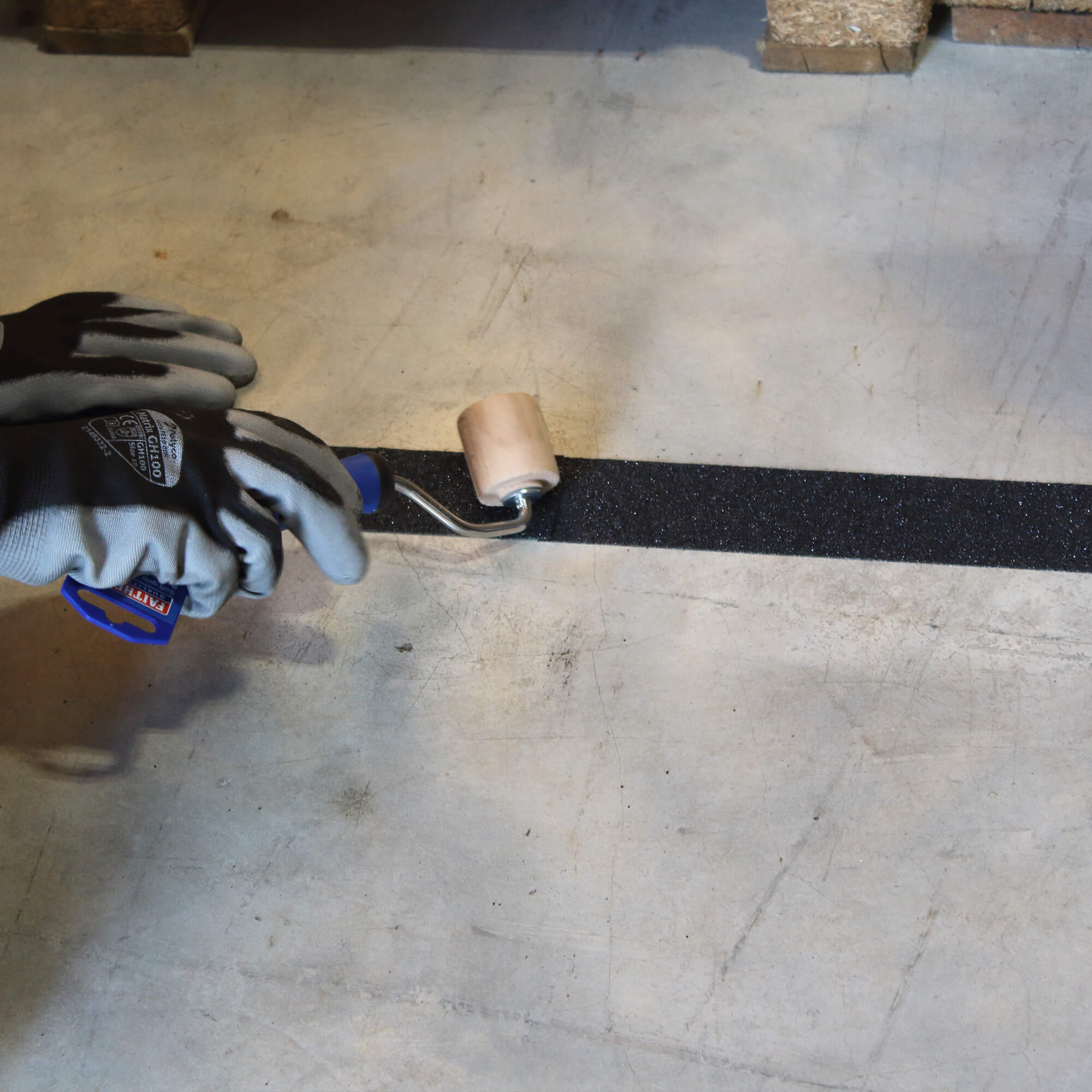Seam roller smoothing black tape during anti-slip installation